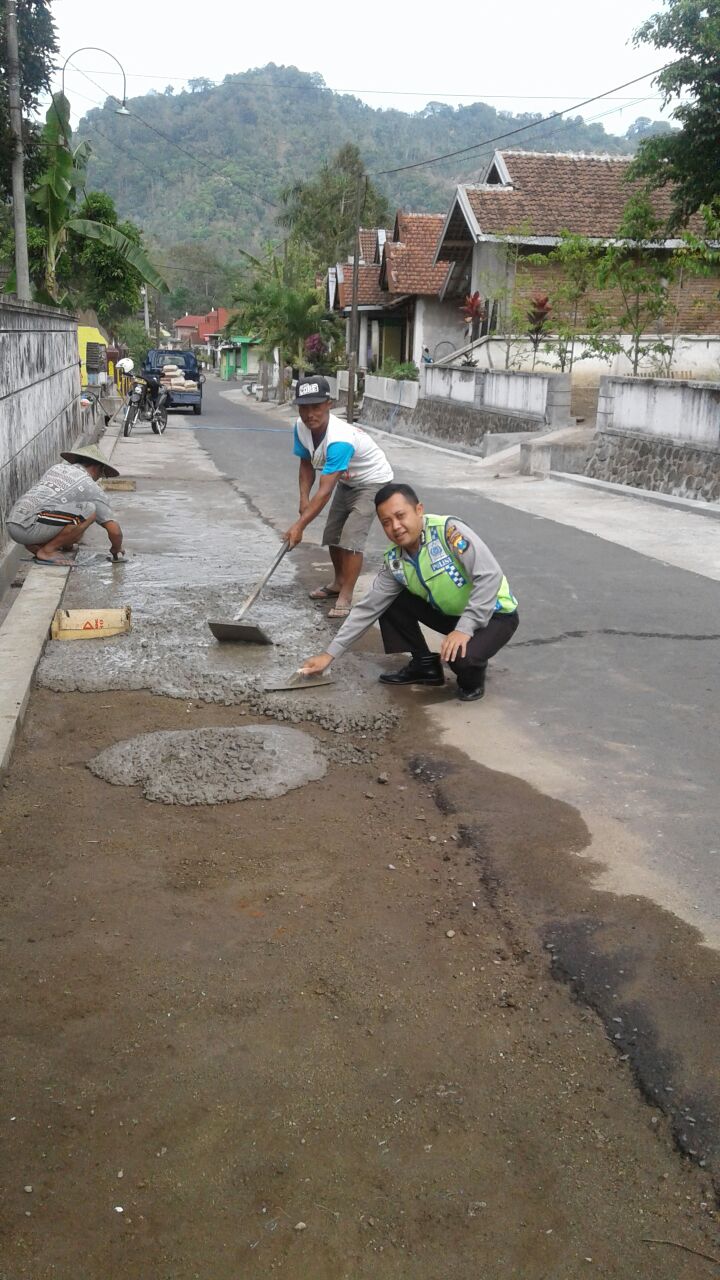 Bhabinkamtibmas Desa Kaumrejo Polsek Ngantang Polres Batu Membantu Warga Perbaiki Jalan Berlubang