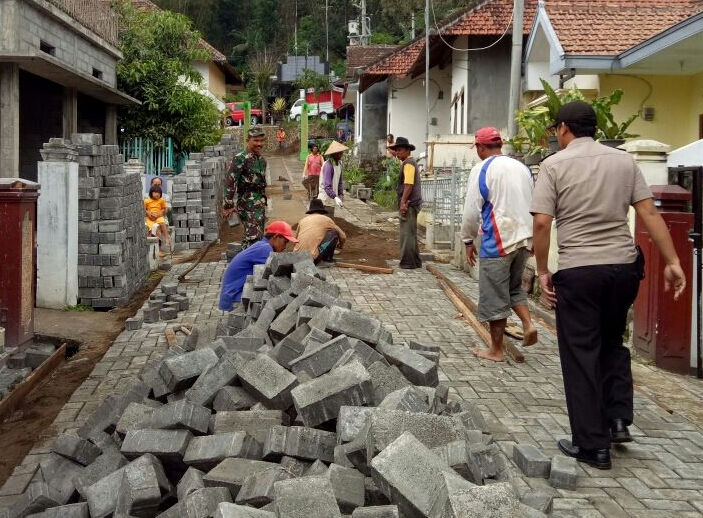 Wujud Pengawalan Dana Desa Bhabin Polsek Batu Polres Batu Gotong Royong Pemasangan Paving Proyek Sumberejo