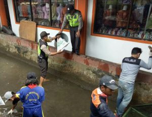 Anggota Polsek Batu Polres Batu Giatkan Membersihkan Sungai Antisipasi Banjir