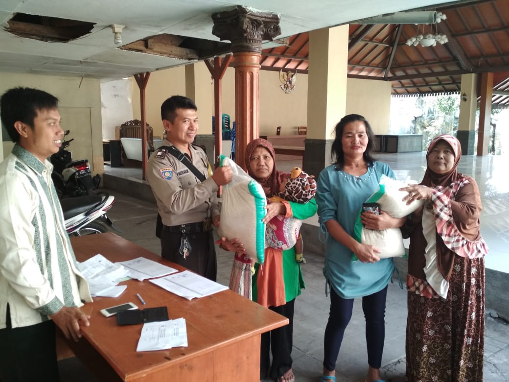 Bhabin desa Pendem Polsek Junrejo Polres Batu melaksanakan pendampingan pembagian sembako pada warga kurang mampu.