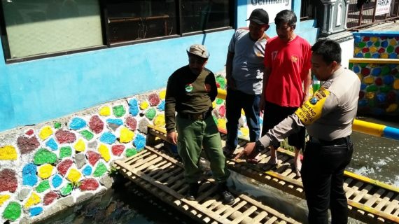 Bhabinkamtibmas Kelurahan Sisir Polsek Batu Kota Polres Batu Bersama Anggota Linmas Pasang Himbauan Untuk Menjaga Ekosistem Ikan Di Sungai