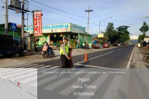 Anggota Polsek Pujon Polres Batu Bantu Kelancaran Arus Lalin