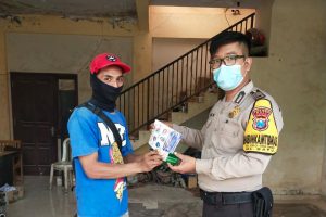 Bagikan ratusan masker dan Stiker, Anggota Bhabinkamtibmas berikan edukasi kepada masyarakat tentang Covid 19