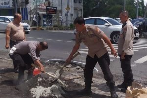 Polisi Bersama TNI dan Warga Tambal Jalan Berlubang di Kota Malang Cegah Kecelakaan
