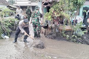Sinergitas Polres Lumajang dan TNI Bantu Bersihkan Rumah Warga Terdampak Banjir di Desa Nguter