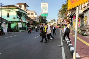 Satlantas Polres Batu Edukasi Tertib Lalu Lintas Lewat Leaflet, Stiker, dan Penyeberangan Siswa Sekolah