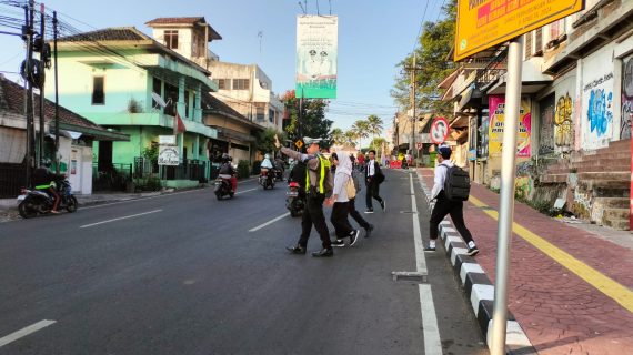 Satlantas Polres Batu Edukasi Tertib Lalu Lintas Lewat Leaflet, Stiker, dan Penyeberangan Siswa Sekolah