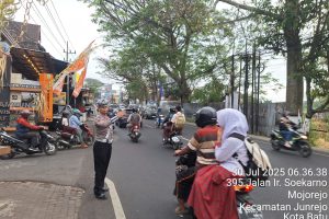 Anggota Satlantas Polres Batu Laksanakan Pengaturan Lalu Lintas di Junrejo, Bantu Anak Sekolah Menyebrang dengan Aman