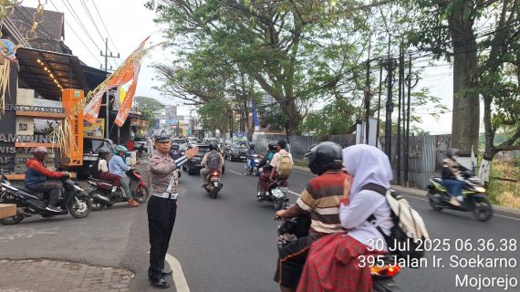 Anggota Satlantas Polres Batu Laksanakan Pengaturan Lalu Lintas di Junrejo, Bantu Anak Sekolah Menyebrang dengan Aman